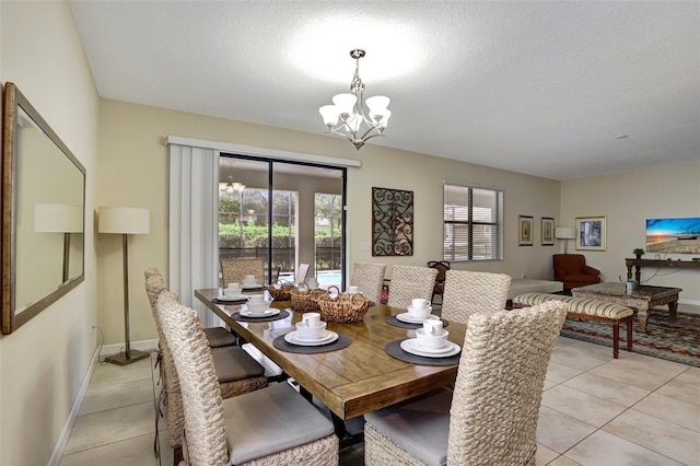 tiled dining space featuring plenty of natural light, a chandelier, and a textured ceiling