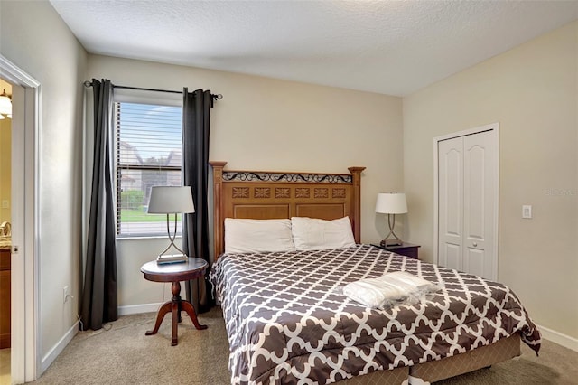 carpeted bedroom featuring a textured ceiling and a closet