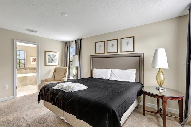 carpeted bedroom featuring ensuite bath and a textured ceiling