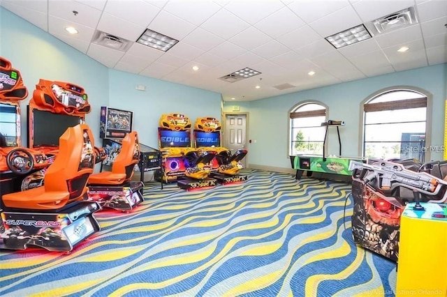 recreation room featuring carpet flooring and a paneled ceiling