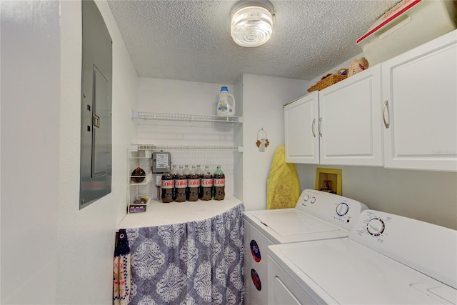 laundry area featuring a textured ceiling, washing machine and dryer, and cabinets