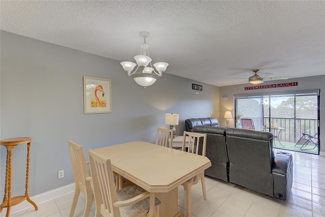 dining space with light tile patterned flooring, a textured ceiling, and ceiling fan with notable chandelier