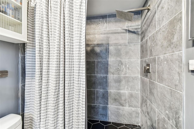 bathroom with a shower with shower curtain and toilet