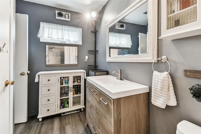 bathroom with vanity, toilet, and wood-type flooring