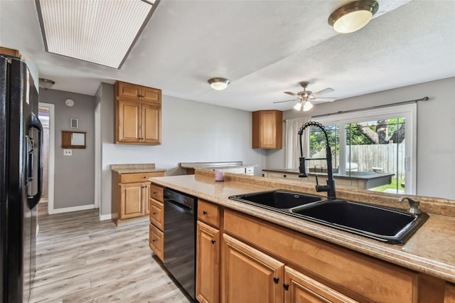 kitchen featuring black appliances, sink, light wood-type flooring, a textured ceiling, and ceiling fan