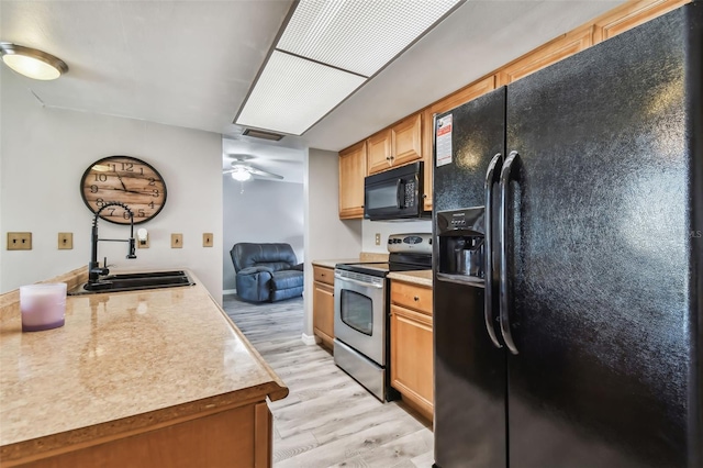 kitchen featuring sink, black appliances, light hardwood / wood-style flooring, and ceiling fan