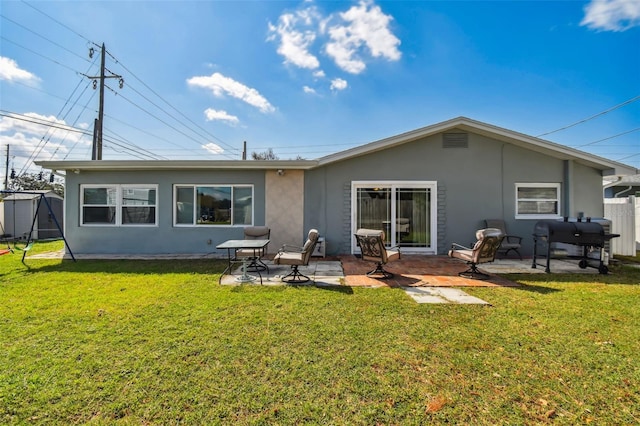 rear view of house featuring a patio and a lawn