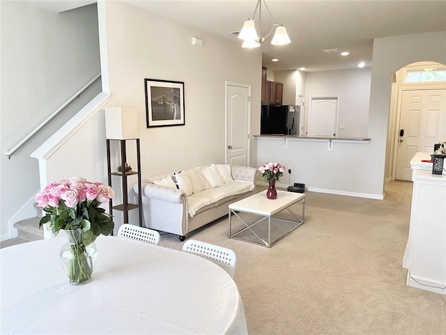 living room with light carpet and a notable chandelier