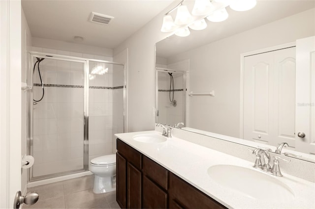 bathroom with tile patterned flooring, an enclosed shower, vanity, and toilet