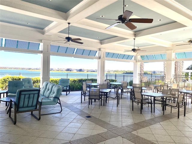 view of patio with ceiling fan and a water view