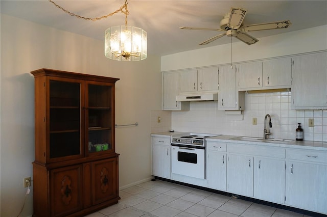 kitchen featuring white electric stove, tasteful backsplash, sink, hanging light fixtures, and light tile patterned floors