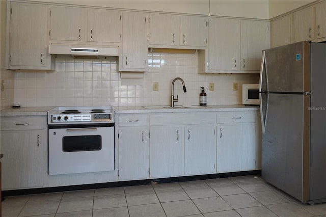 kitchen with white appliances, sink, light tile patterned floors, and tasteful backsplash