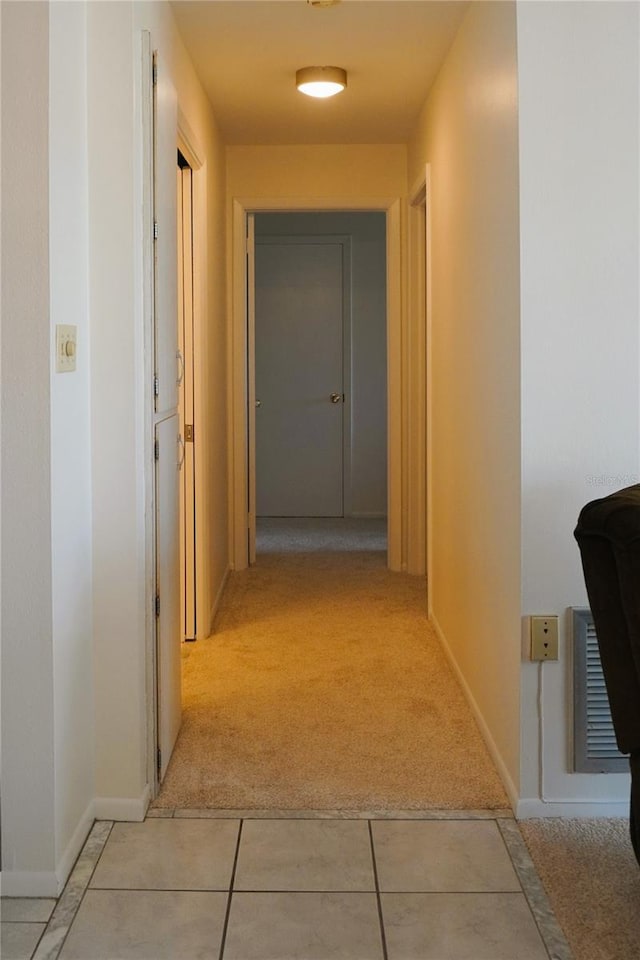4338 Tahitian Gardens Cir Unit C, Holiday, FL 34691 - hallway with light colored carpet, baseboards, and light tile patterned floors