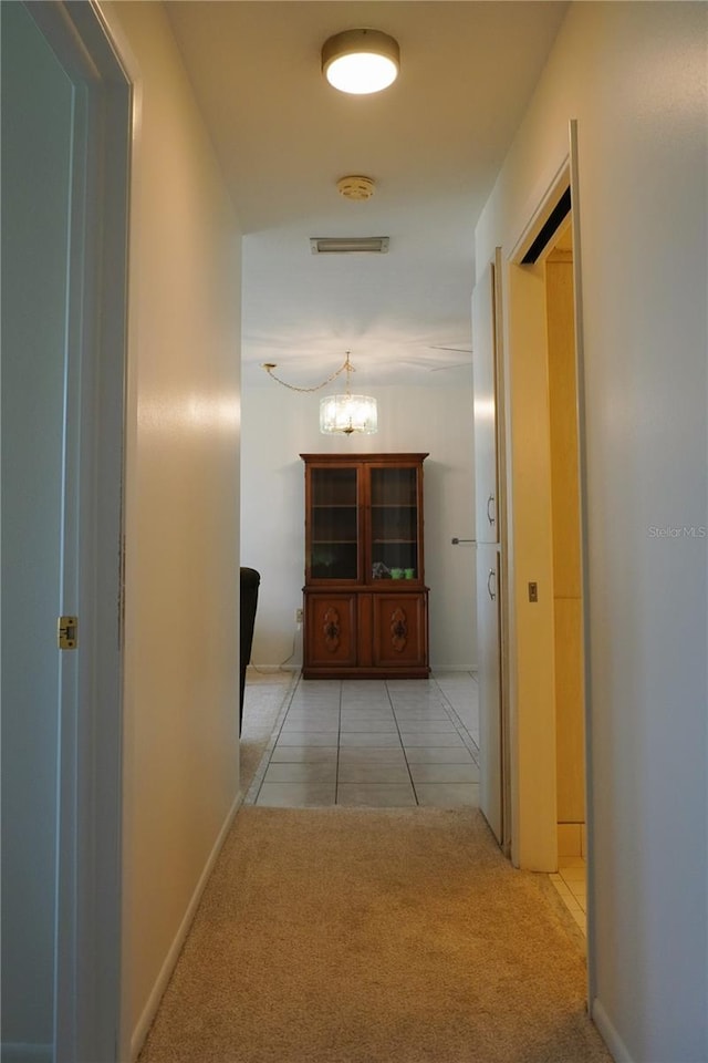 4338 Tahitian Gardens Cir Unit C, Holiday, FL 34691 - corridor featuring light carpet, a chandelier, and light tile patterned floors