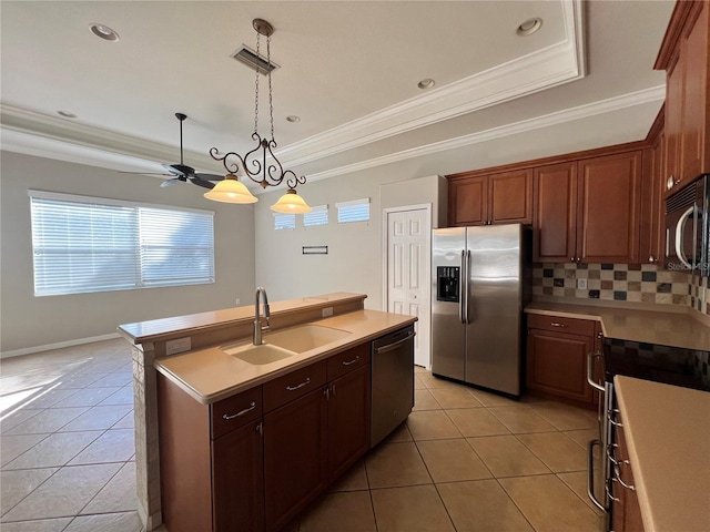 kitchen with a kitchen island with sink, tasteful backsplash, sink, appliances with stainless steel finishes, and decorative light fixtures