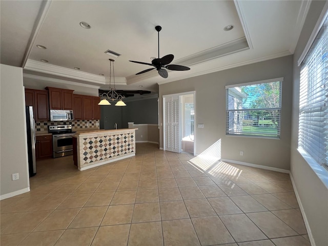 kitchen featuring a wealth of natural light, stainless steel appliances, and a raised ceiling