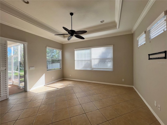 spare room featuring ceiling fan, a raised ceiling, crown molding, and light tile patterned floors