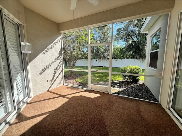 unfurnished sunroom with ceiling fan and a wealth of natural light