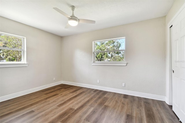 unfurnished bedroom featuring multiple windows and dark hardwood / wood-style floors