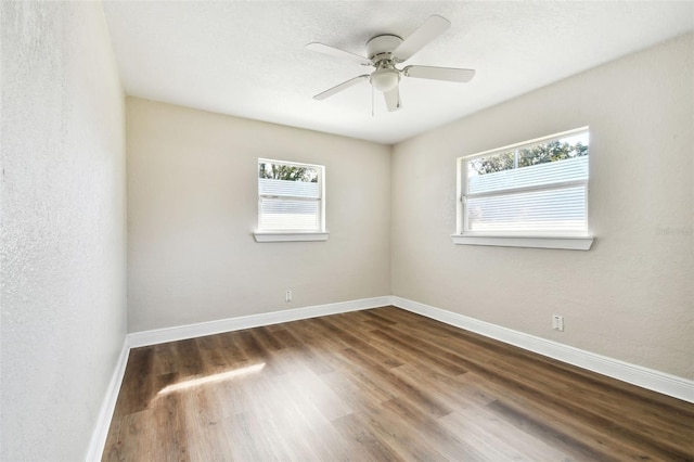 empty room with ceiling fan and dark wood-type flooring