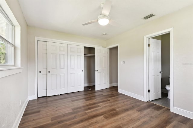 unfurnished bedroom featuring a closet, connected bathroom, ceiling fan, and dark hardwood / wood-style flooring