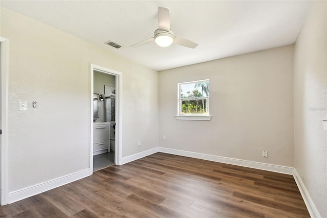 unfurnished bedroom with dark hardwood / wood-style flooring, connected bathroom, and ceiling fan