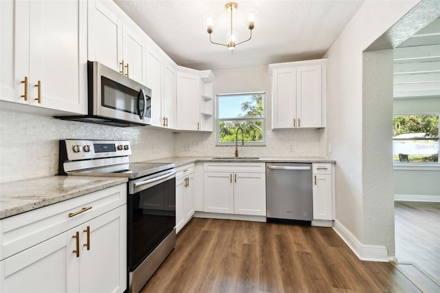 kitchen with backsplash, white cabinets, sink, appliances with stainless steel finishes, and dark hardwood / wood-style flooring