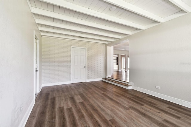 empty room with dark hardwood / wood-style floors, beam ceiling, wood ceiling, and brick wall