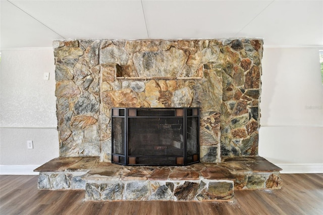 interior details featuring a fireplace, wood-type flooring, and ornamental molding