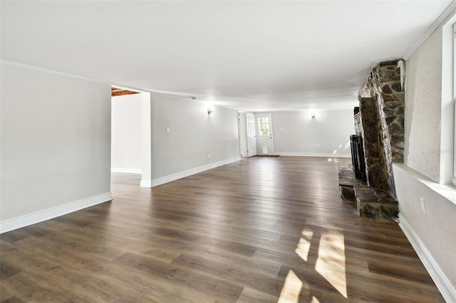 unfurnished living room featuring a fireplace, dark hardwood / wood-style floors, and ornamental molding