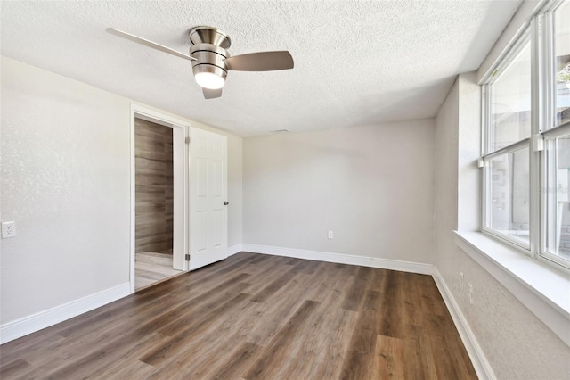 spare room featuring ceiling fan, dark hardwood / wood-style flooring, and a healthy amount of sunlight