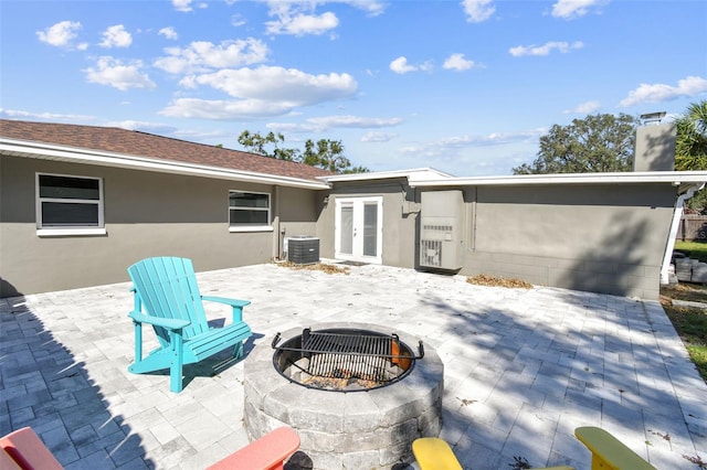 view of patio featuring french doors, an outdoor fire pit, and cooling unit