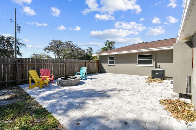 view of patio featuring cooling unit and a fire pit