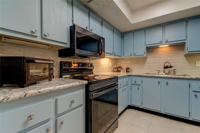 kitchen featuring blue cabinetry, electric range, sink, backsplash, and light tile patterned floors