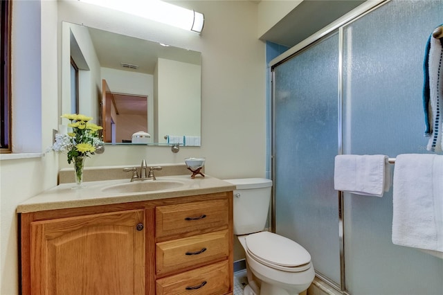 bathroom with vanity, walk in shower, and toilet