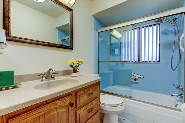 full bathroom featuring bath / shower combo with glass door, tile patterned floors, vanity, and toilet