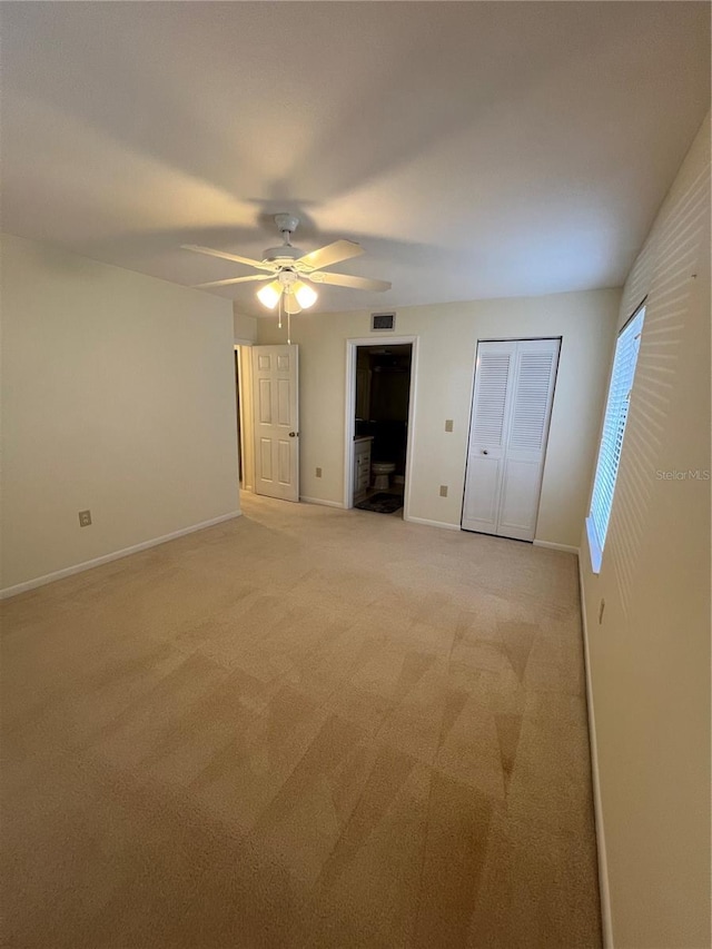 unfurnished bedroom with ceiling fan and light colored carpet