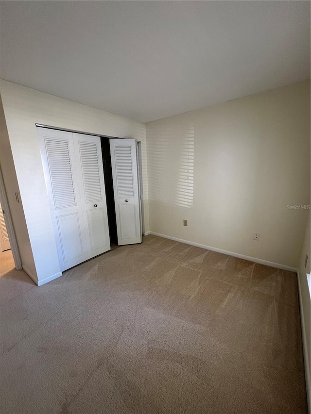 unfurnished bedroom with carpet floors and a closet