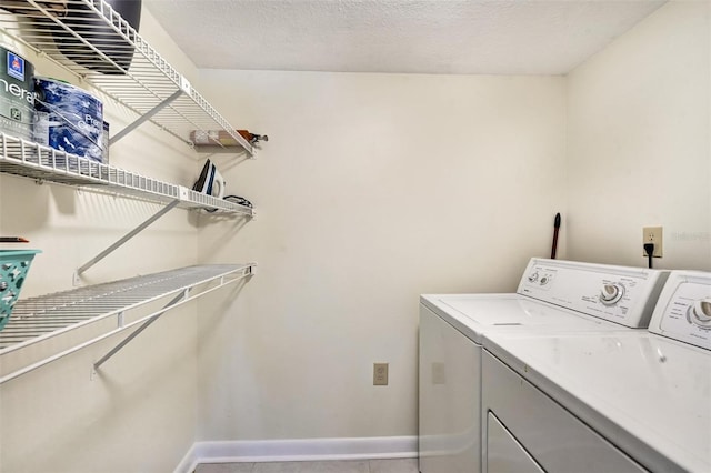 laundry room featuring washing machine and dryer and a textured ceiling