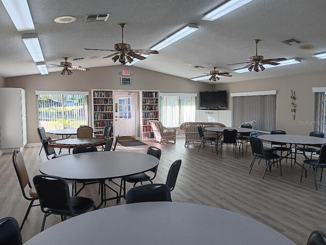 dining room with ceiling fan, light wood-type flooring, and lofted ceiling