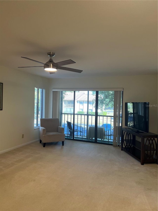 unfurnished living room with ceiling fan and light carpet