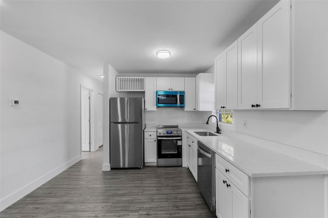 kitchen with stainless steel appliances, dark hardwood / wood-style floors, sink, and white cabinets