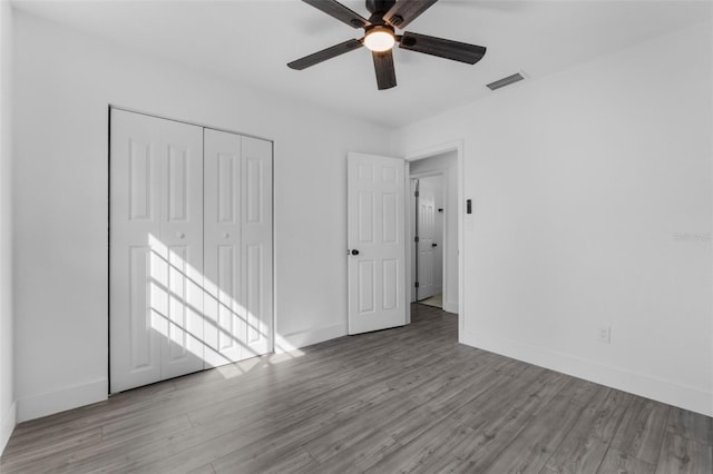 unfurnished bedroom with ceiling fan, a closet, and light wood-type flooring