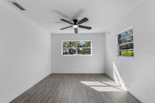 unfurnished room featuring ceiling fan, plenty of natural light, and wood-type flooring