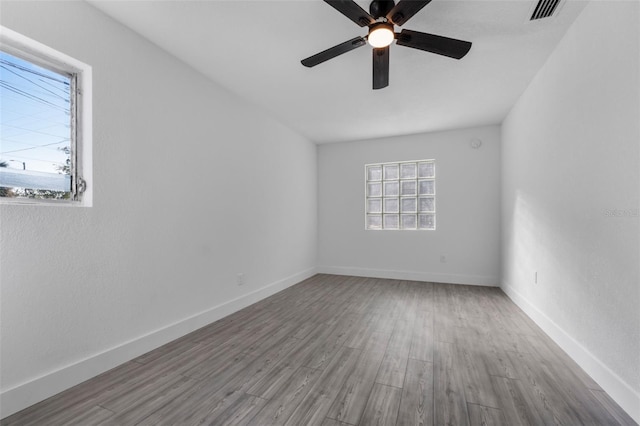 spare room featuring ceiling fan, plenty of natural light, and wood-type flooring