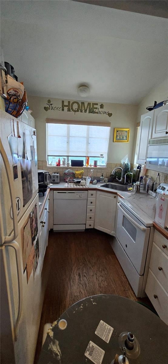 kitchen featuring backsplash, white cabinetry, dark wood-type flooring, sink, and white appliances