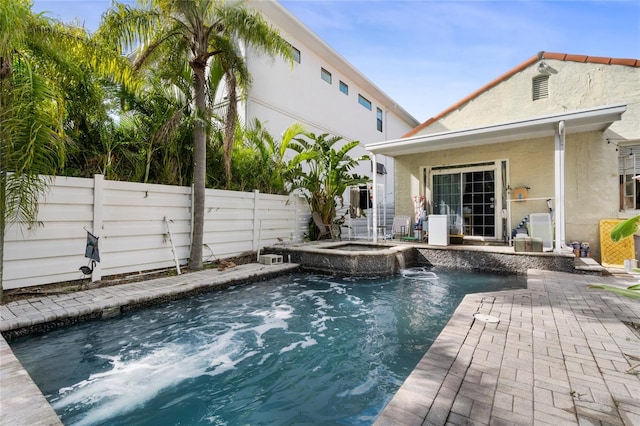 view of swimming pool with a patio, pool water feature, and an in ground hot tub