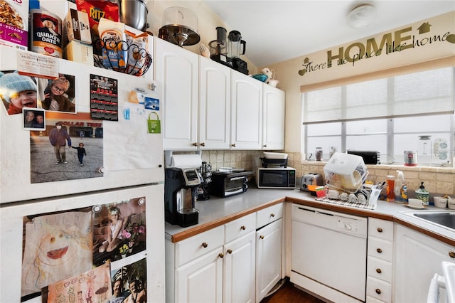 kitchen featuring white appliances, white cabinetry, and decorative backsplash