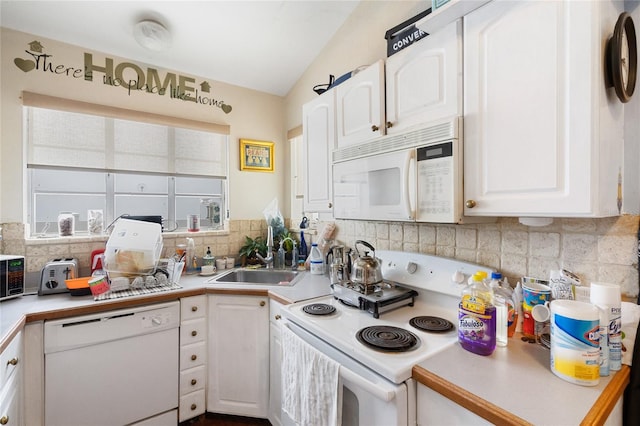 kitchen featuring lofted ceiling, backsplash, sink, white cabinetry, and white appliances