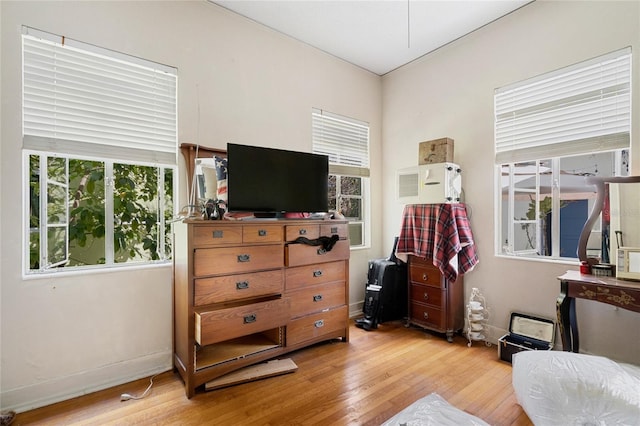 bedroom with multiple windows and light wood-type flooring